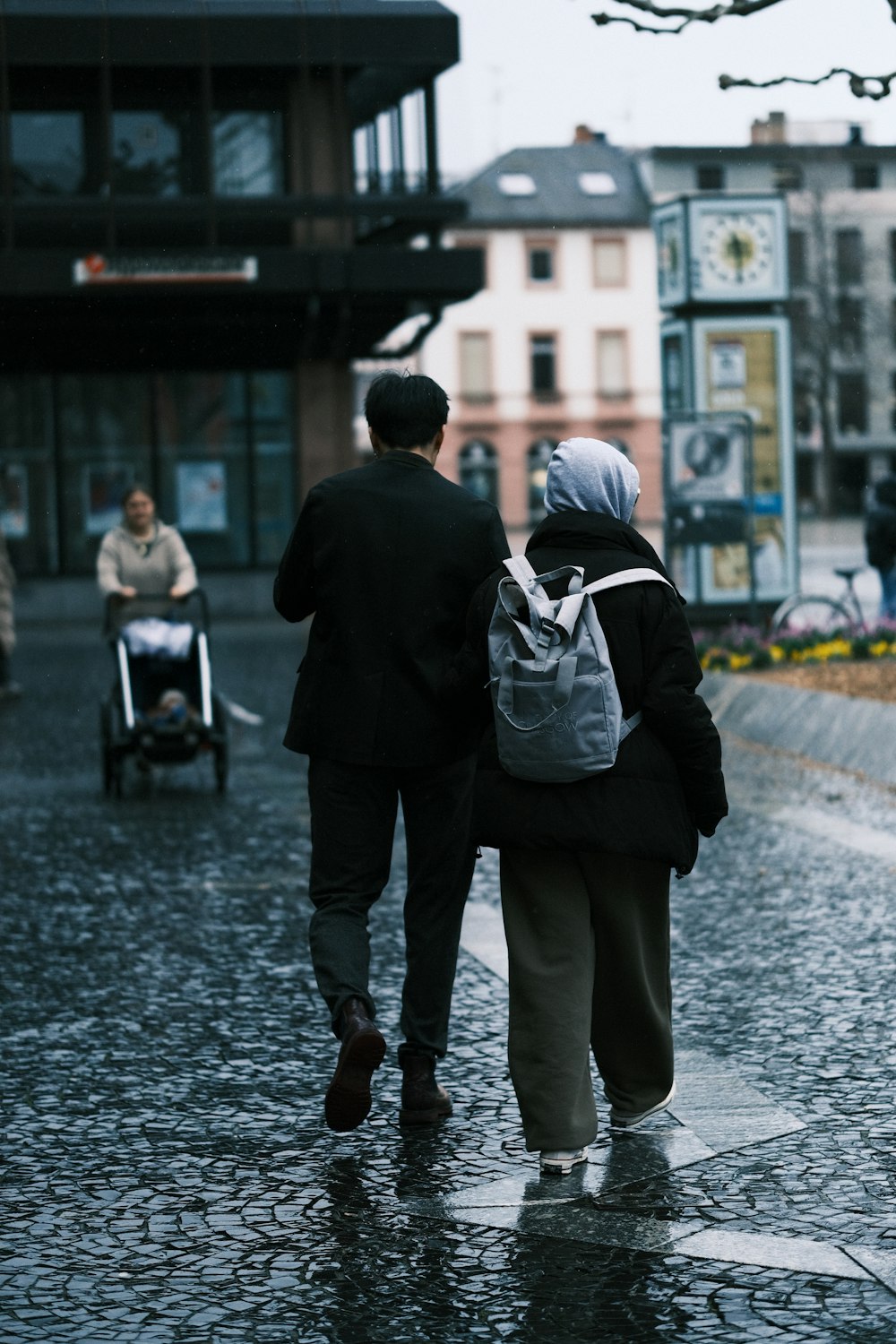a man and a woman walking down a street in the rain