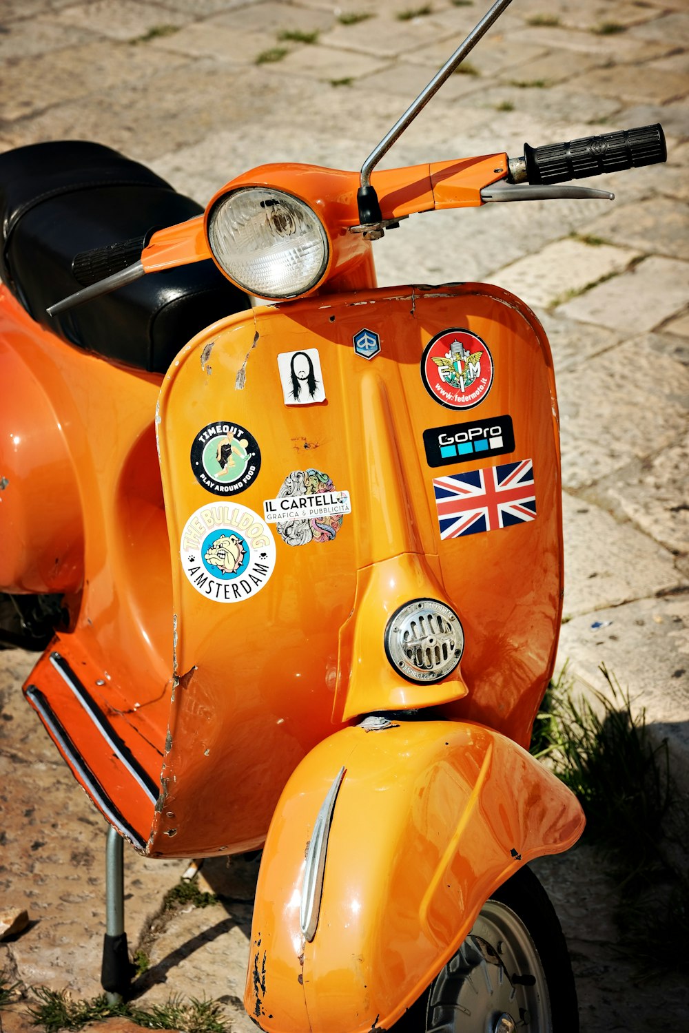 an orange scooter with stickers on it