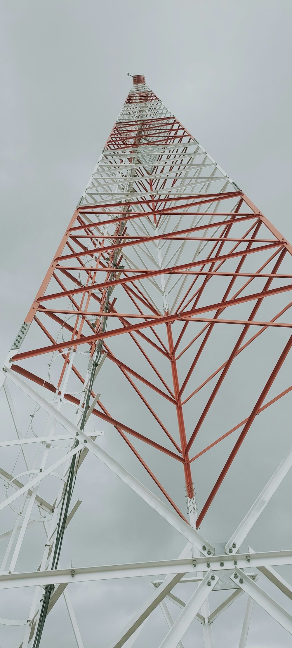 a red and white tower on a cloudy day