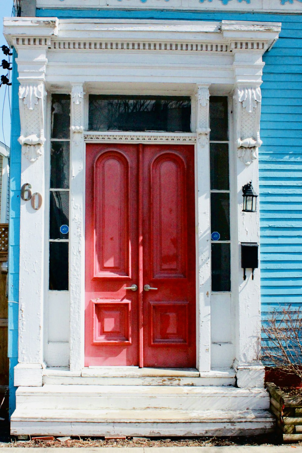 a red door sits in front of a blue building