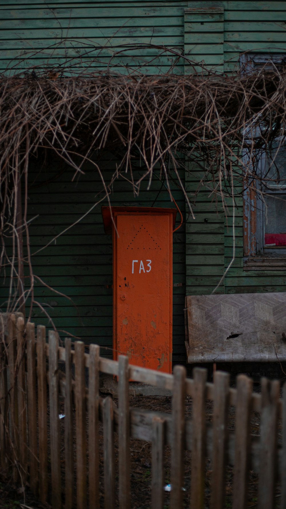 an orange door sitting in front of a green building