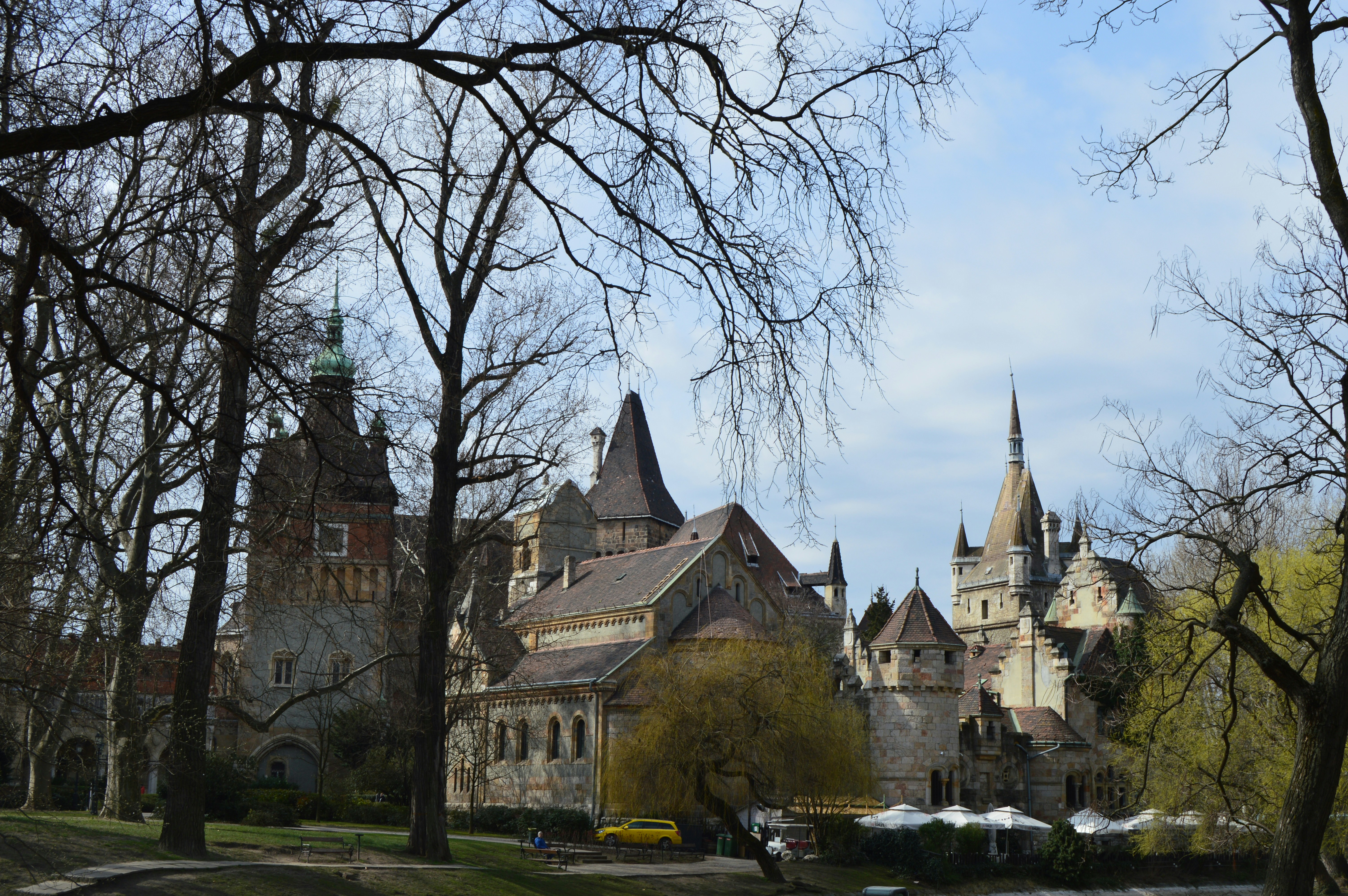a large castle with a clock tower in the middle of a park