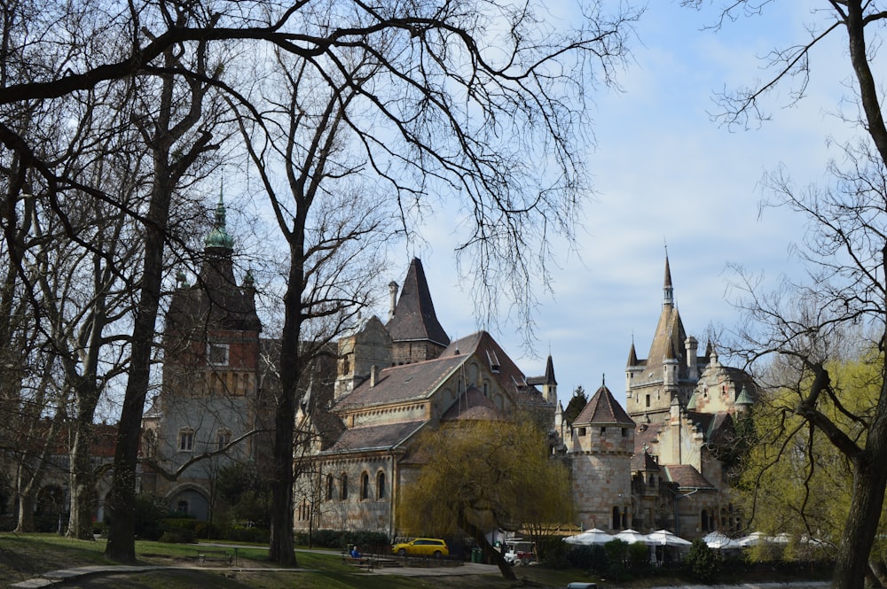 a large castle with a clock tower in the middle of a park