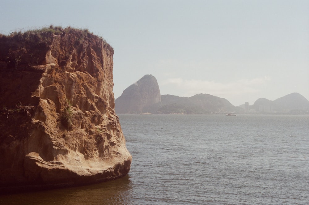 a large rock sticking out of a body of water