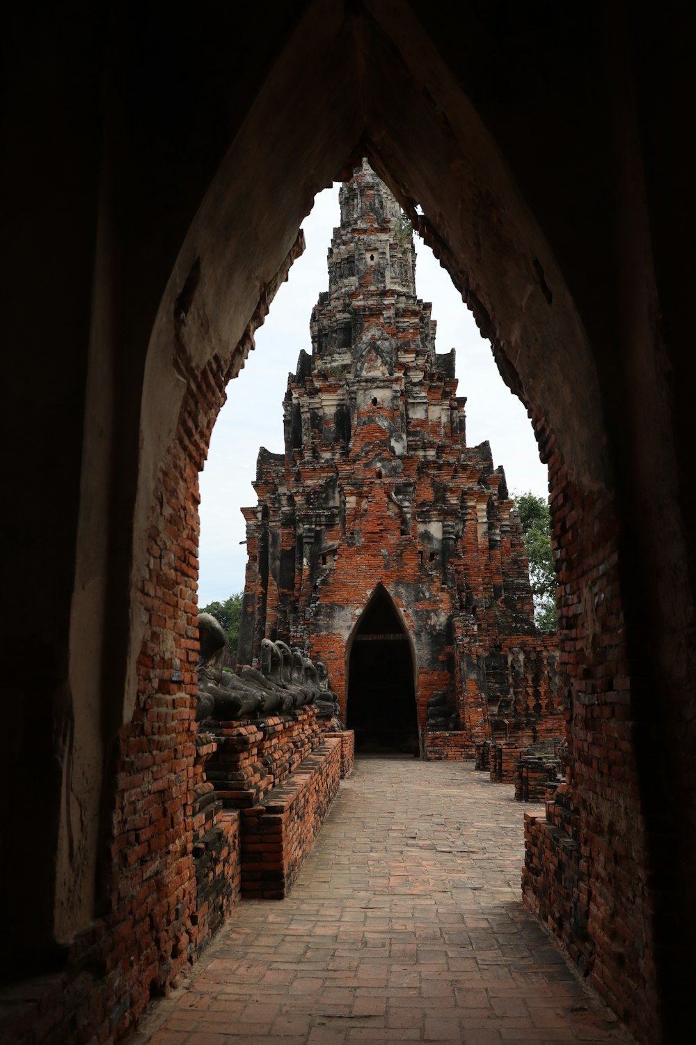 a stone archway with a brick walkway leading to it