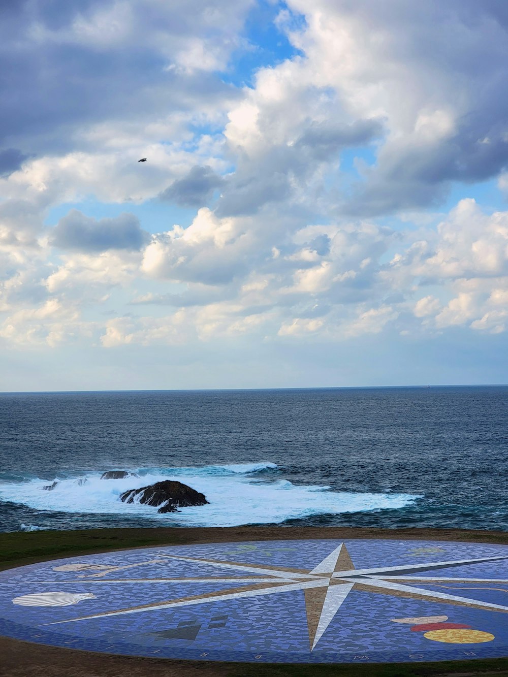 a large star on the ground next to the ocean