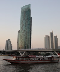 a large boat floating on top of a river next to a tall building
