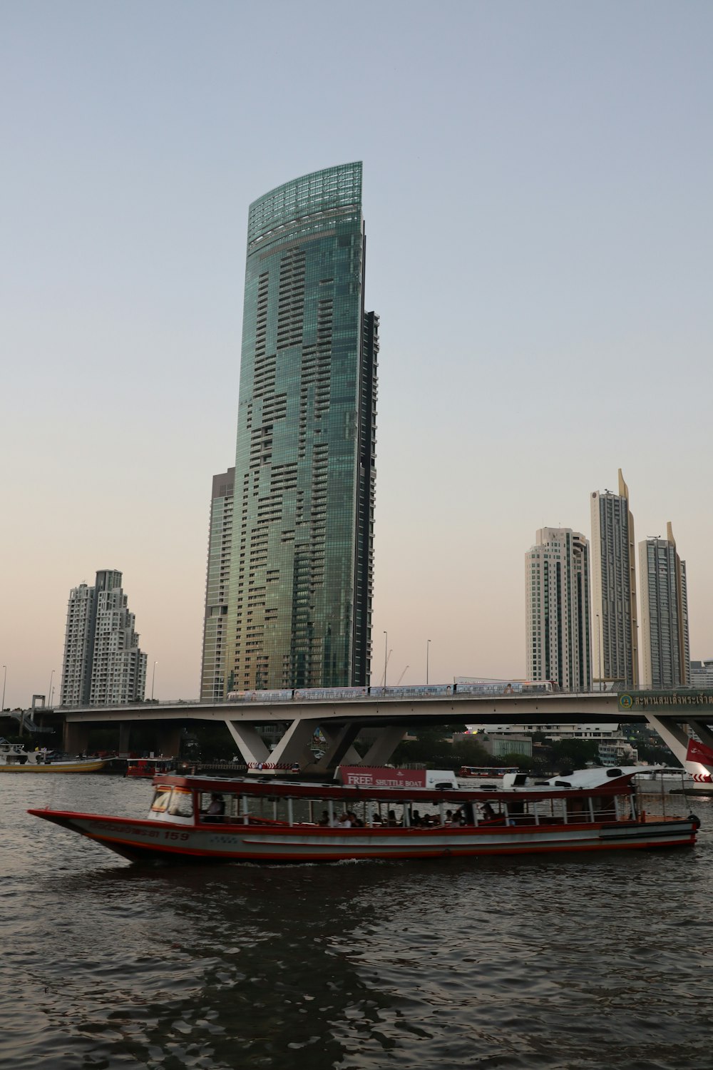a large boat floating on top of a river next to a tall building