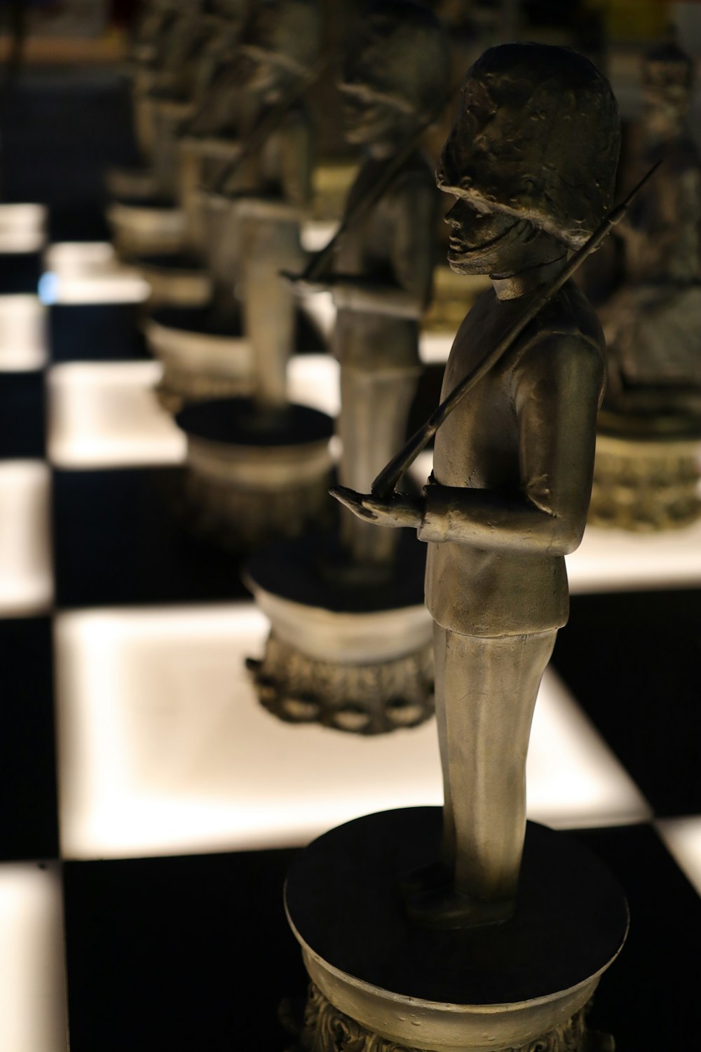 a black and white checkered floor with a statue of a boy holding a broom