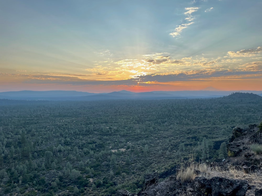 the sun is setting over the mountains in the distance