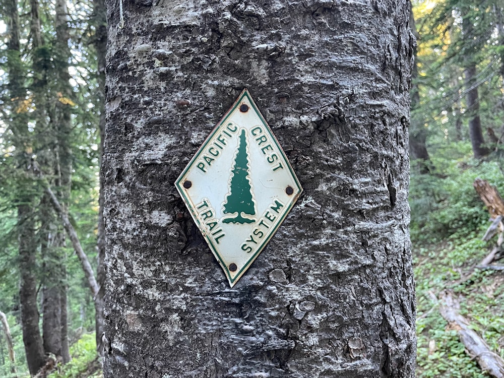 a sign on the side of a tree in the woods