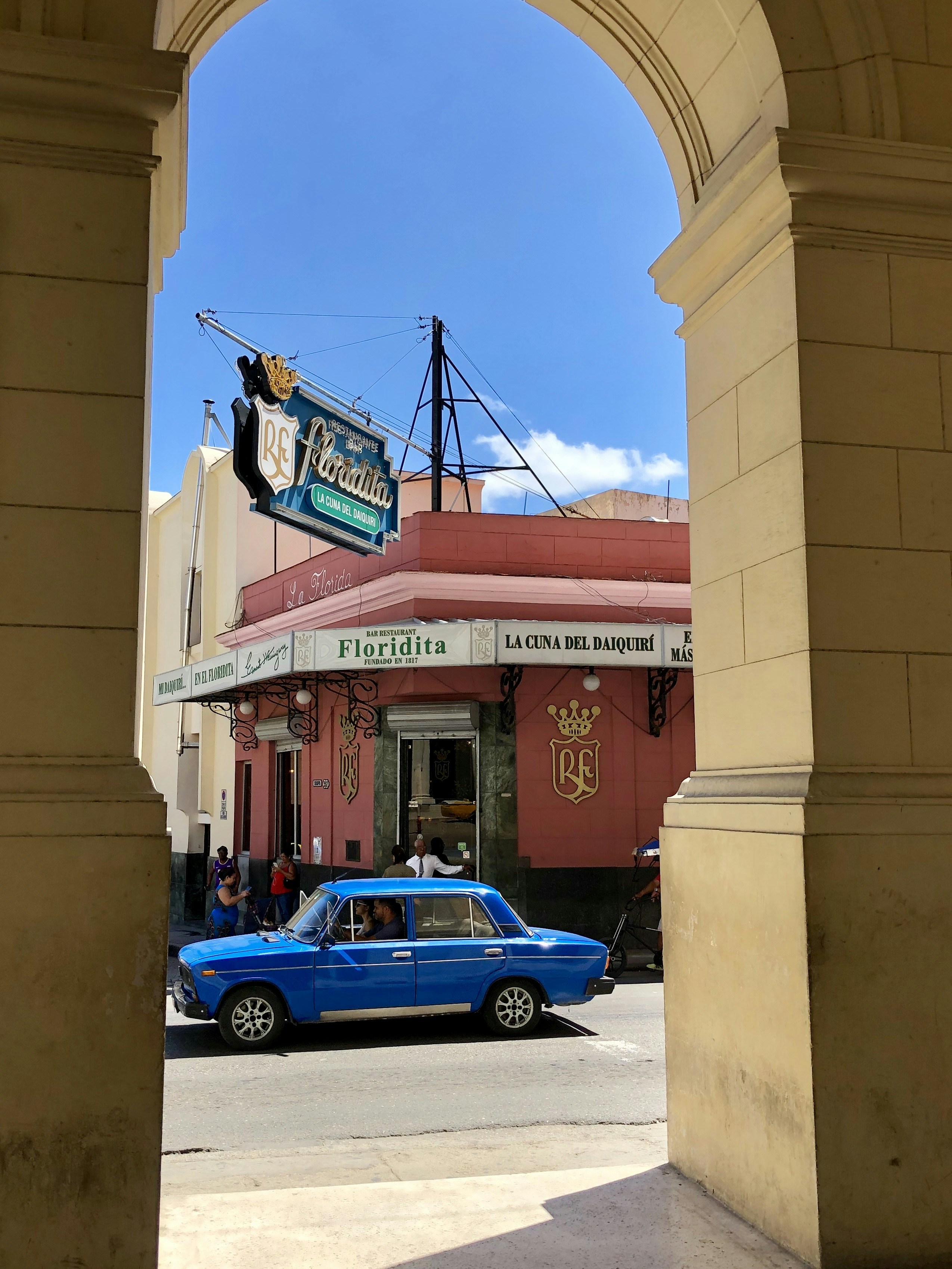 a blue car is parked in front of a building