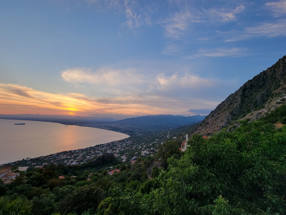 uma vista panorâmica de um lago e montanhas ao pôr do sol