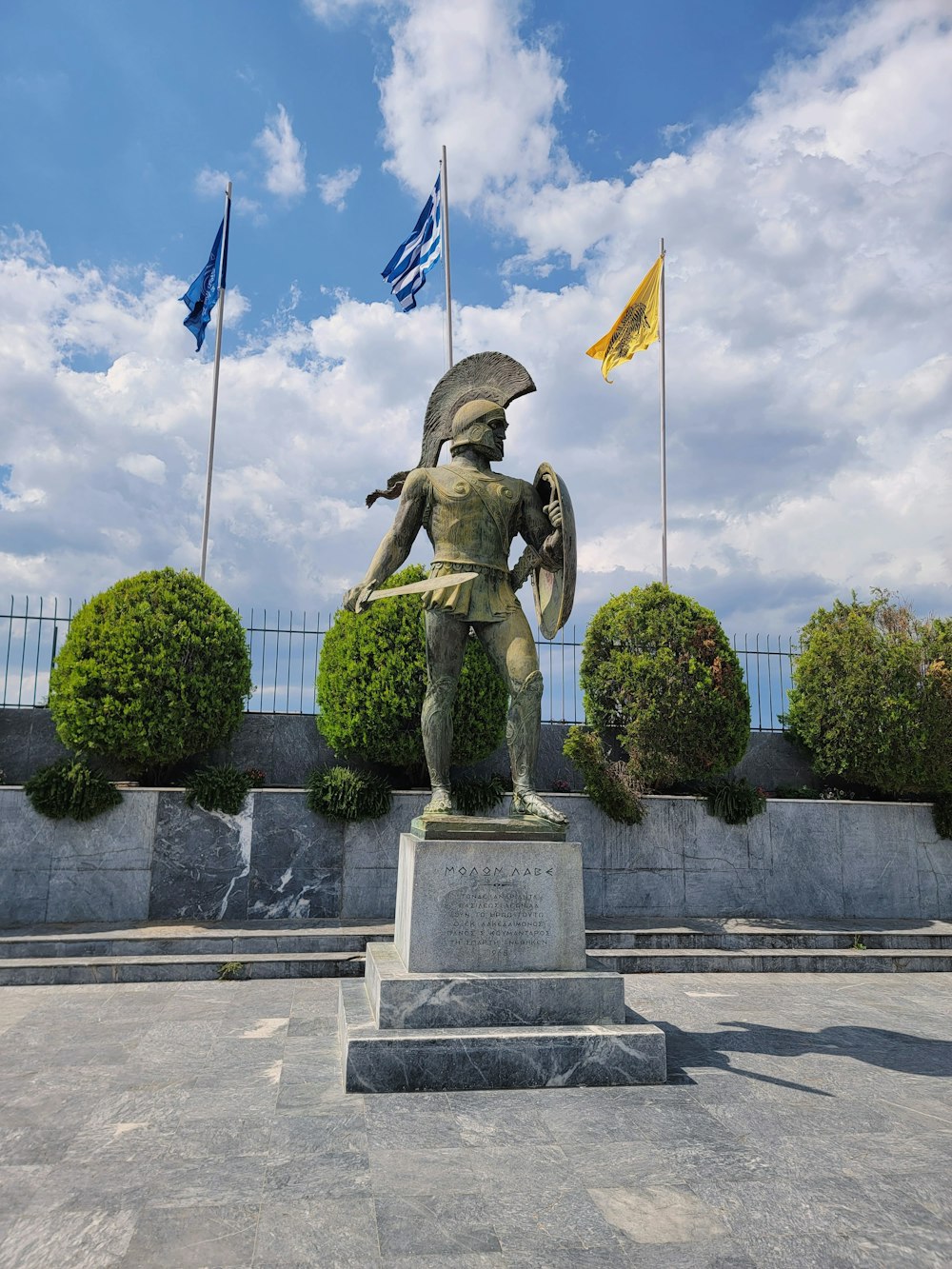 eine Statue eines Mannes, der einen Schild und einen Schild hält