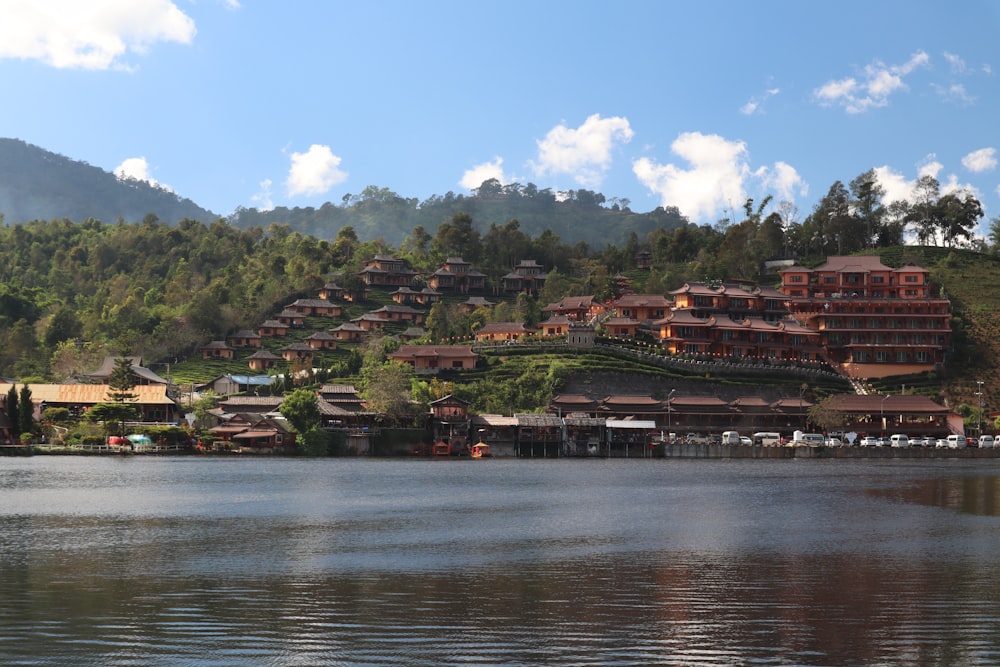 a large body of water next to a lush green hillside