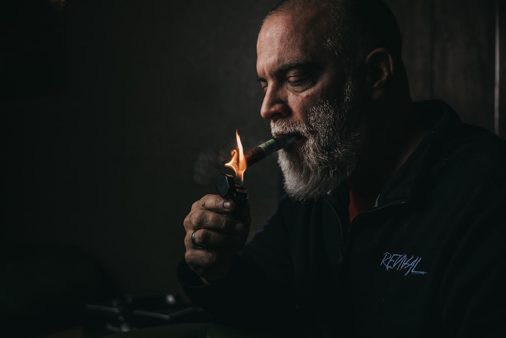 a man smoking a cigarette in a dark room