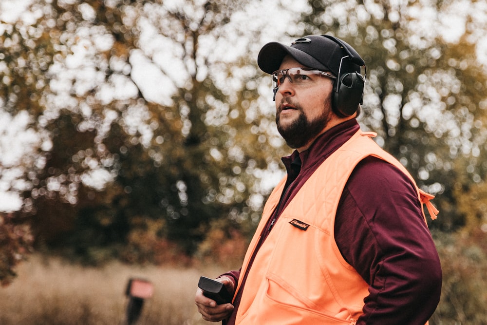 a man in an orange vest and headphones