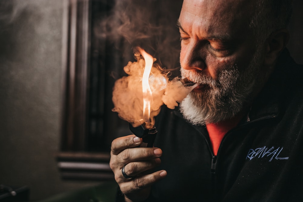 a man with a beard holding a lighter in his hand