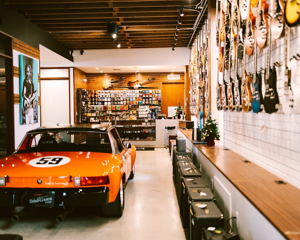 Une voiture de sport orange est garée dans un magasin