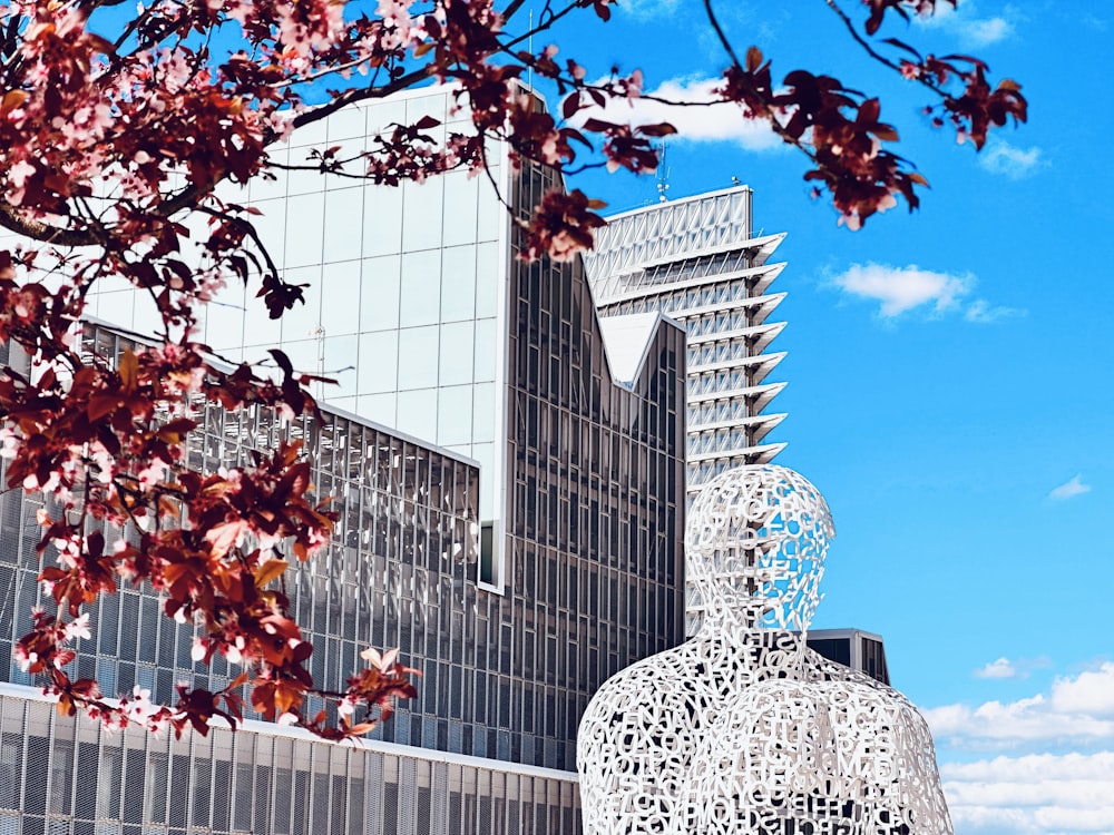 a tall building with a sculpture in front of it