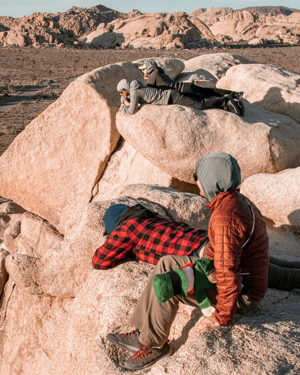 a man sitting on top of a rock next to another man