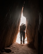 a man is walking through a narrow tunnel