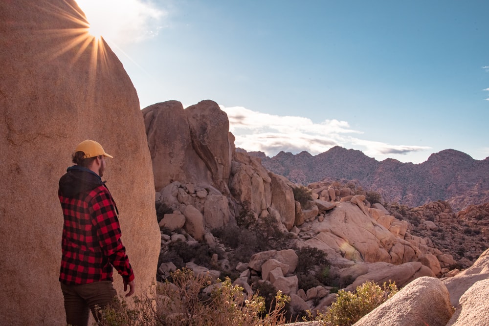 a man standing on top of a rock next to a mountain