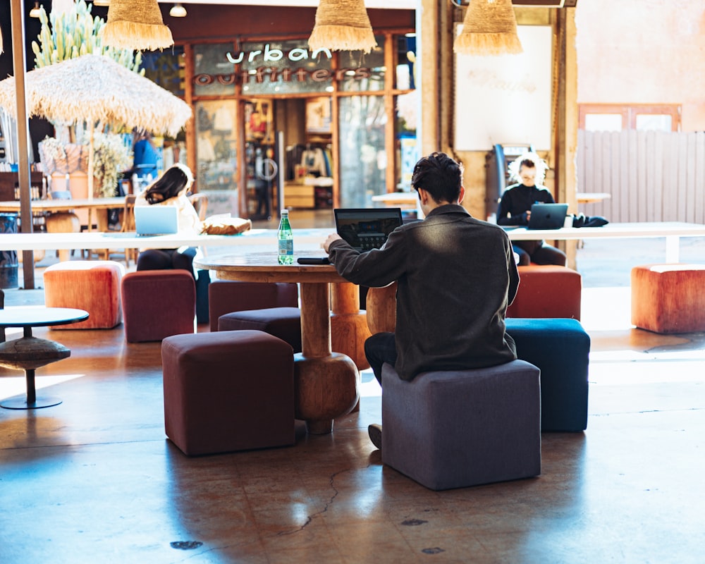 a man sitting at a table with a laptop