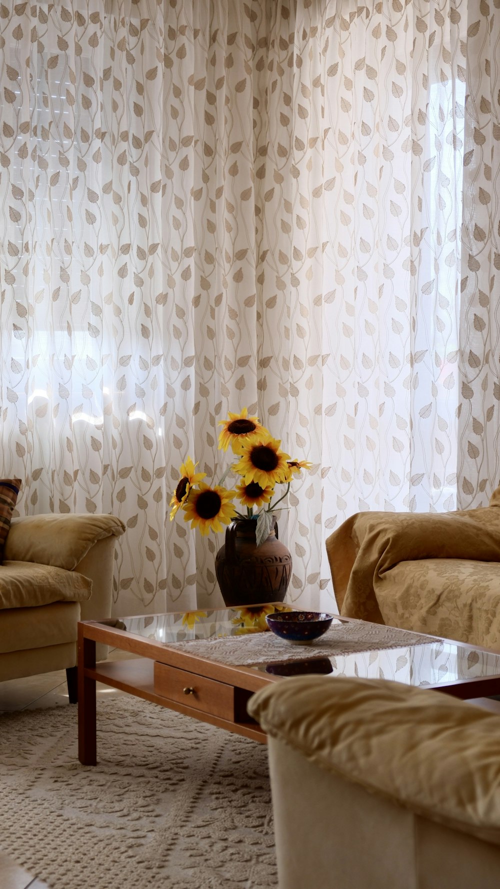 a living room filled with furniture and a vase of sunflowers