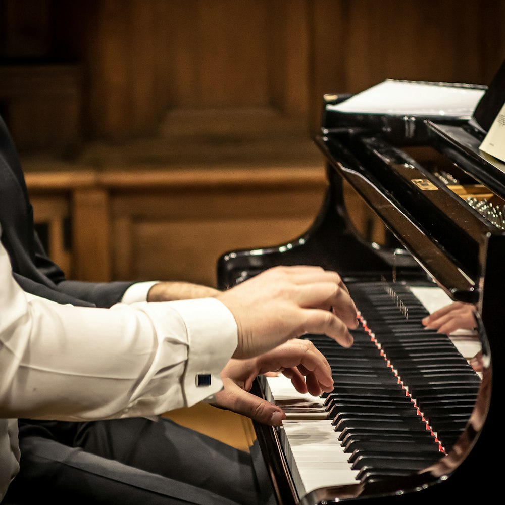a man sitting at a piano playing a musical instrument