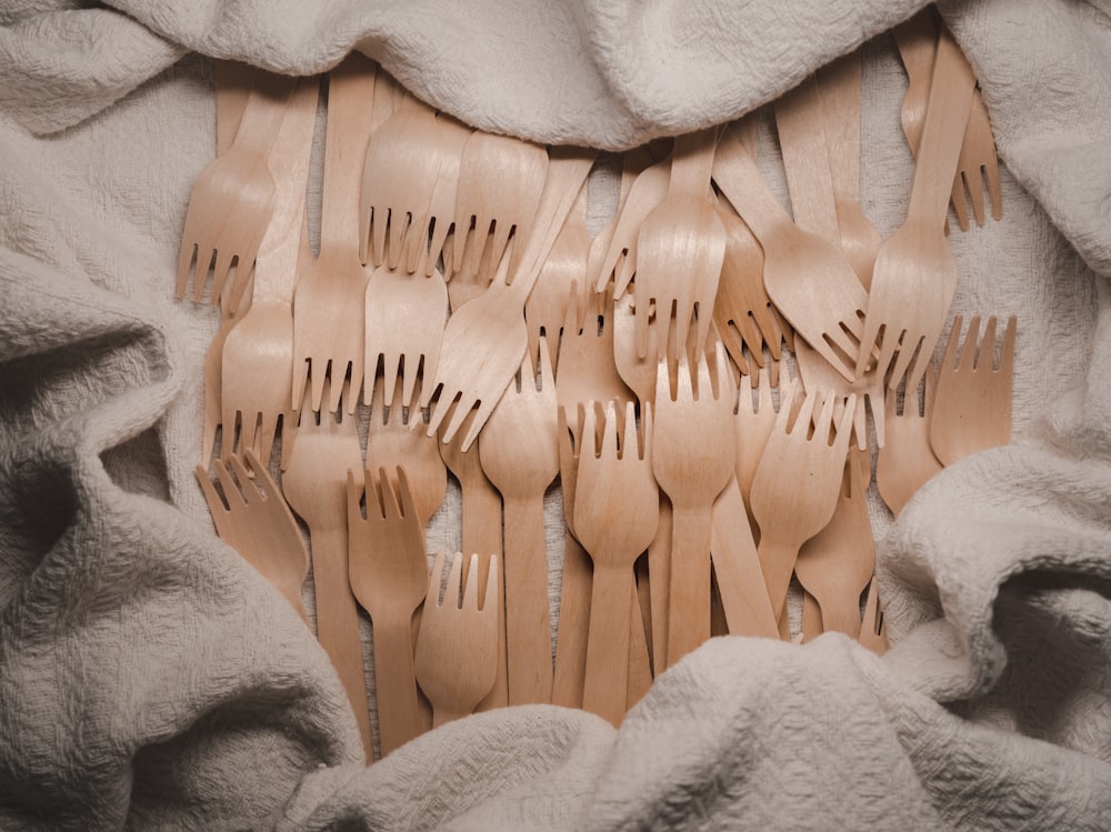 a pile of wooden forks sitting on top of a blanket