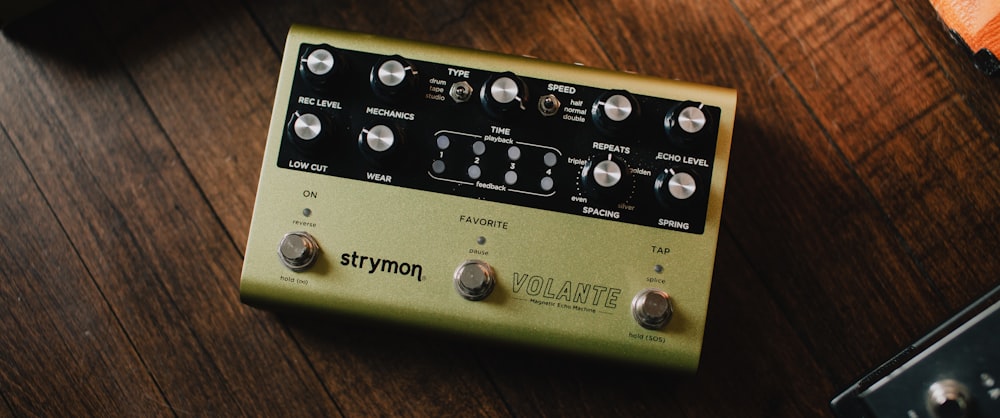 a close up of a guitar pedal over a wooden table