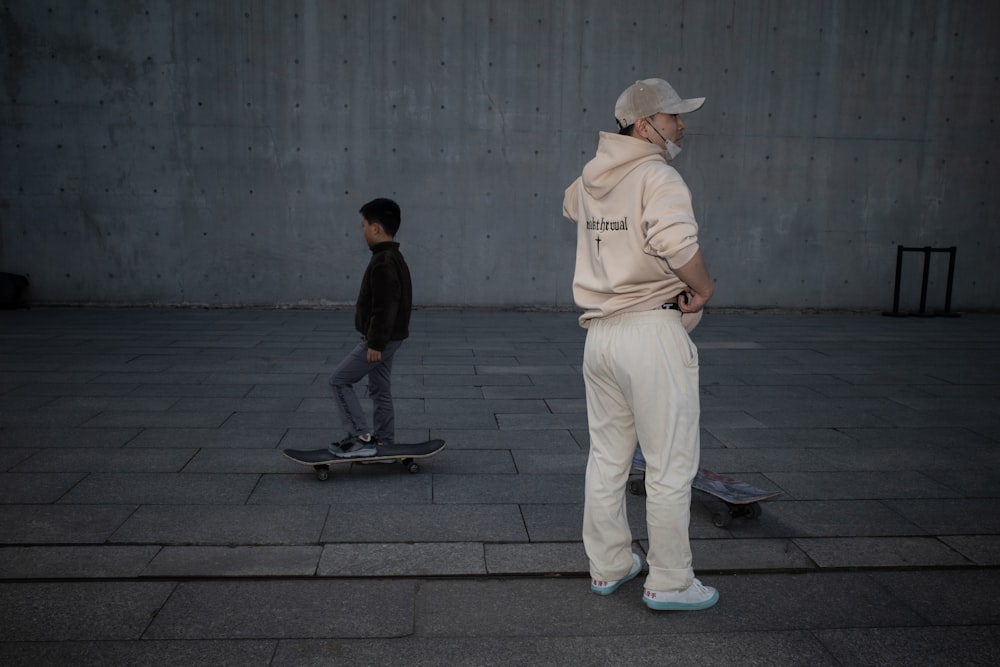 a man standing next to a boy on a skateboard