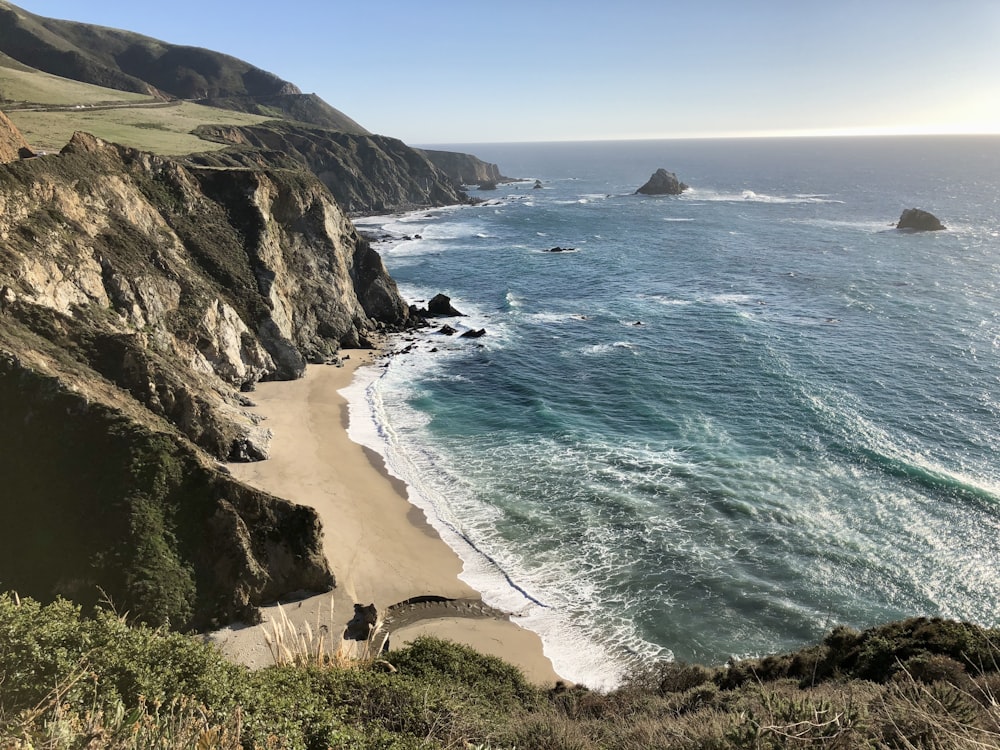 a view of a beach from a cliff overlooking the ocean