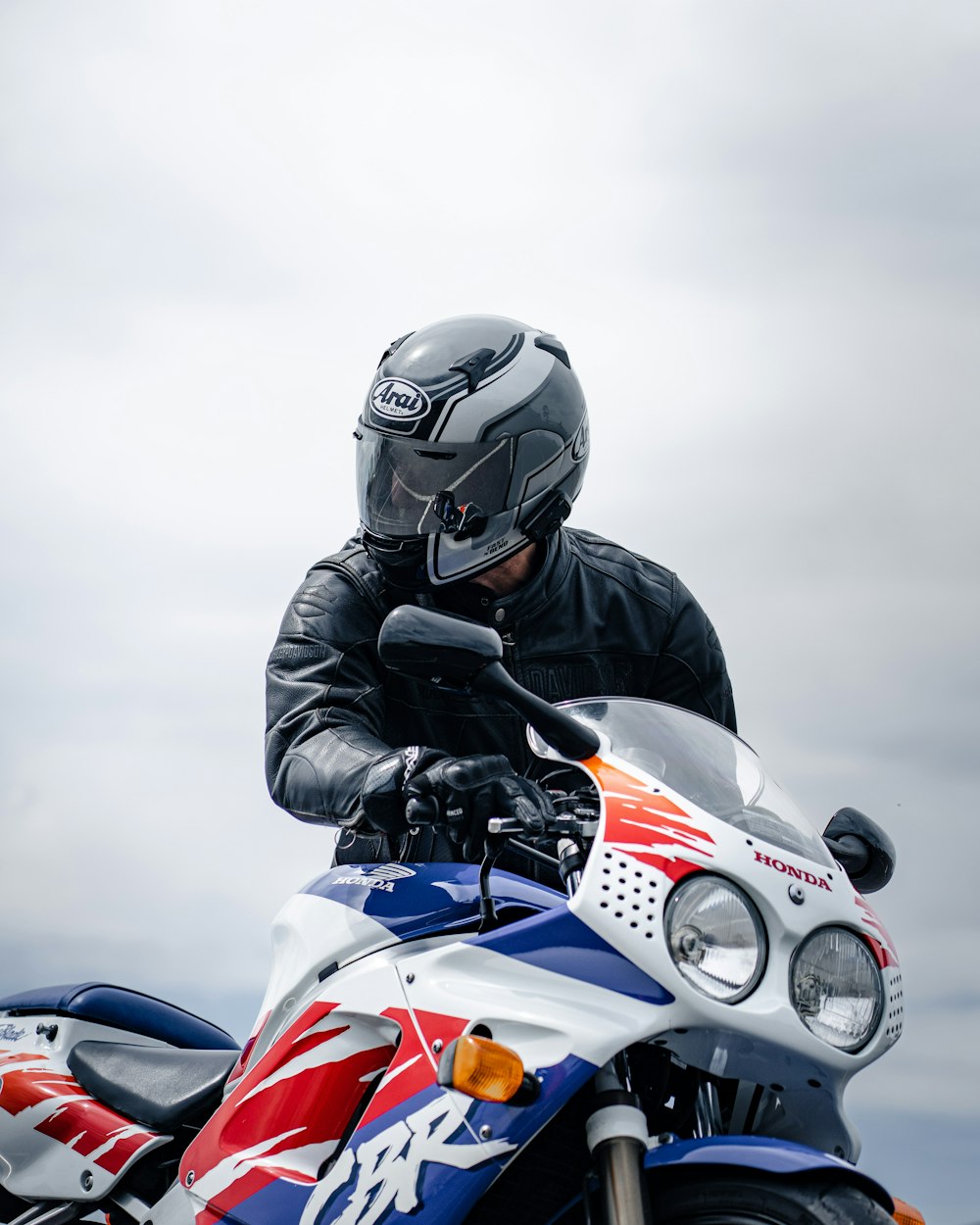 a man riding a motorcycle on a cloudy day