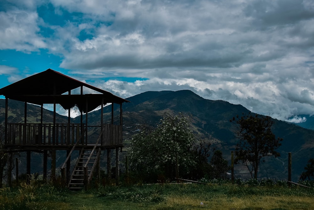 a wooden structure sitting on top of a lush green hillside