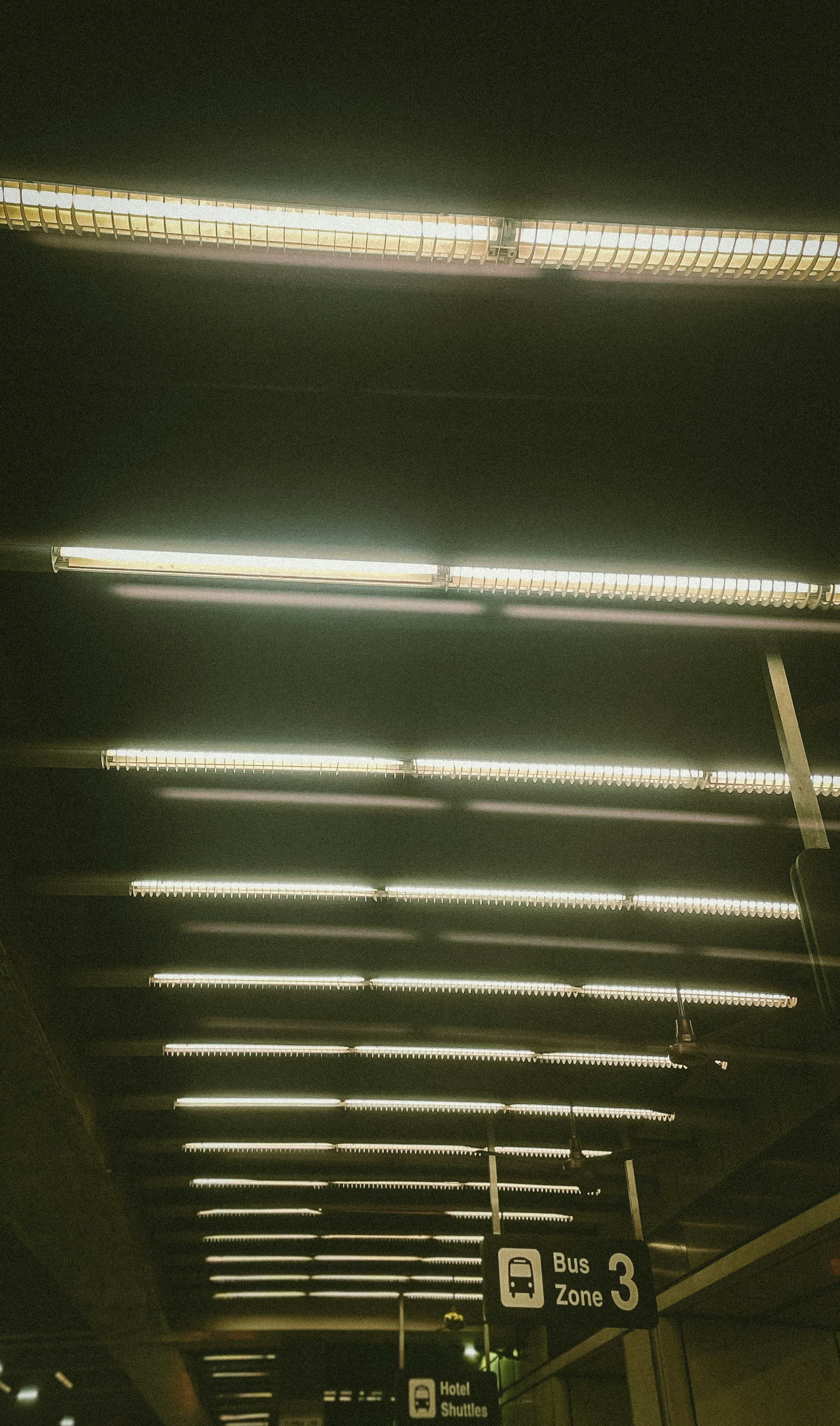 a train station with a bunch of lights hanging from the ceiling