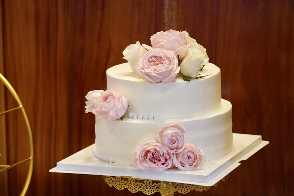 a three tiered wedding cake with pink flowers on top
