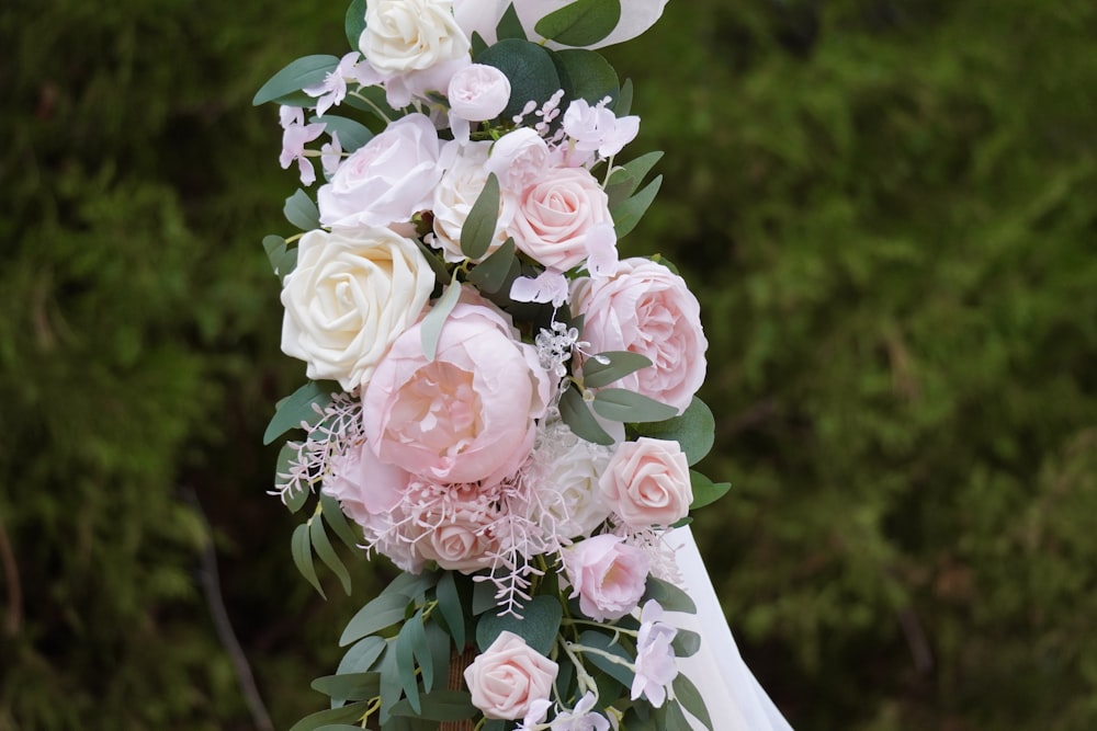 a bride holding a bouquet of pink and white flowers