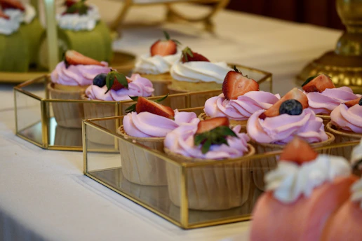 a table topped with cupcakes covered in frosting