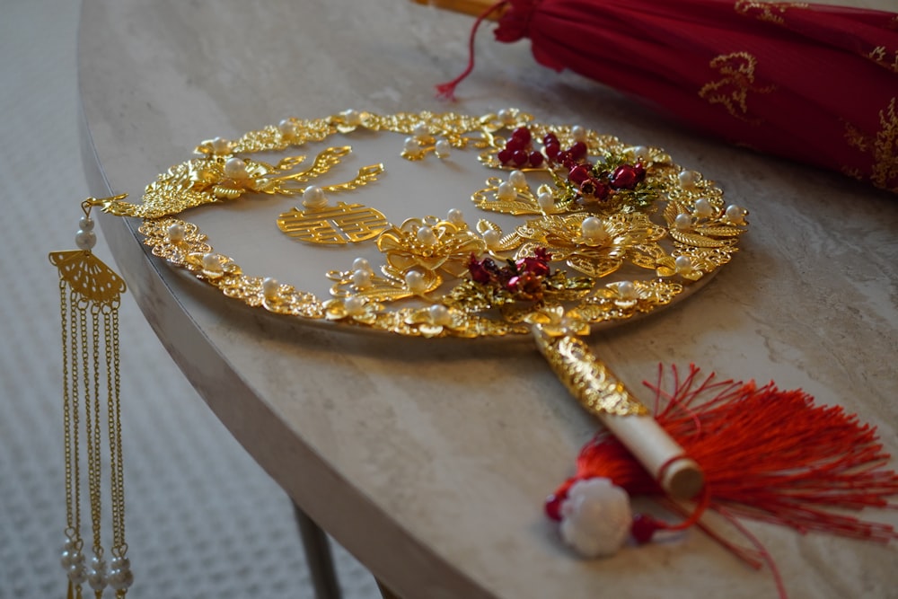 a gold plate with a red tassel on top of it