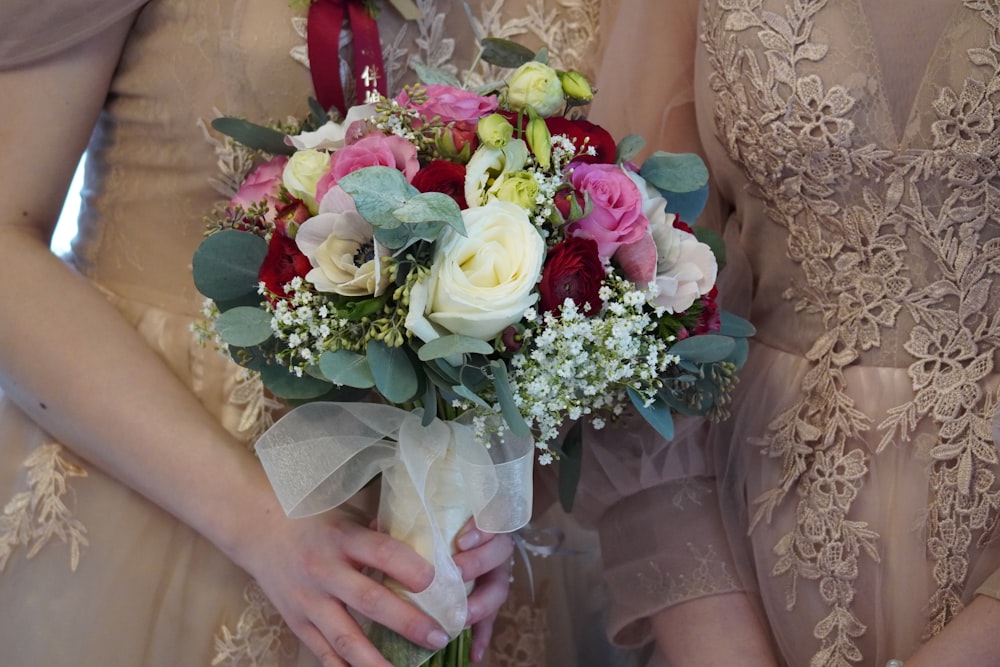 a close up of two bridesmaids holding bouquets of flowers