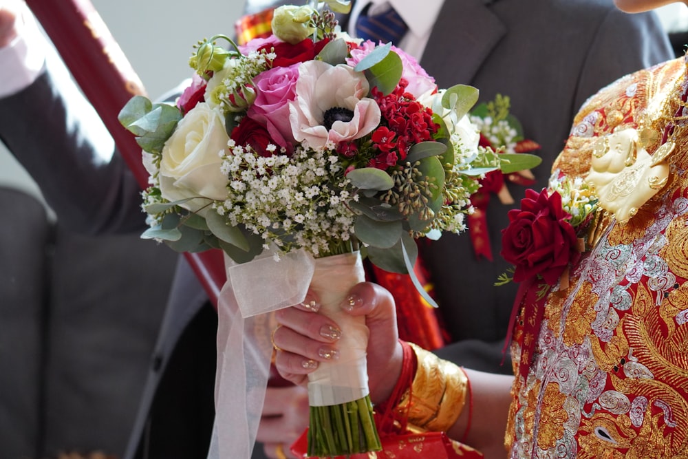 a close up of a person holding a bouquet of flowers