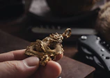 A close-up of a young protagonist with expressive eyes, holding a glowing, golden dragon scale.