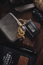 a wallet with a keychain and a watch on top of it