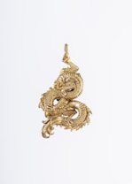An intricately designed gold dragon pendant, expertly crafted with detailed scales and a flowing tail, forming a visually striking and elegant piece of jewelry.
