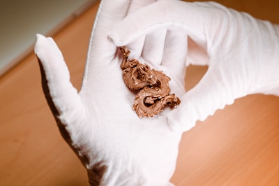 Hand holding a finely detailed 3D printed miniature sculpture with an industrial finish.