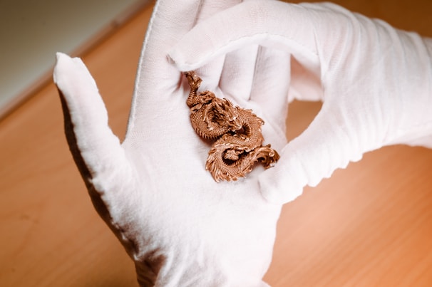 A close-up of hands carefully handling a fragile collectible figure, reflecting the passion and care behind the shop.