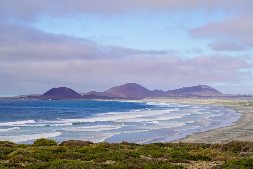 a view of a beach with mountains in the background