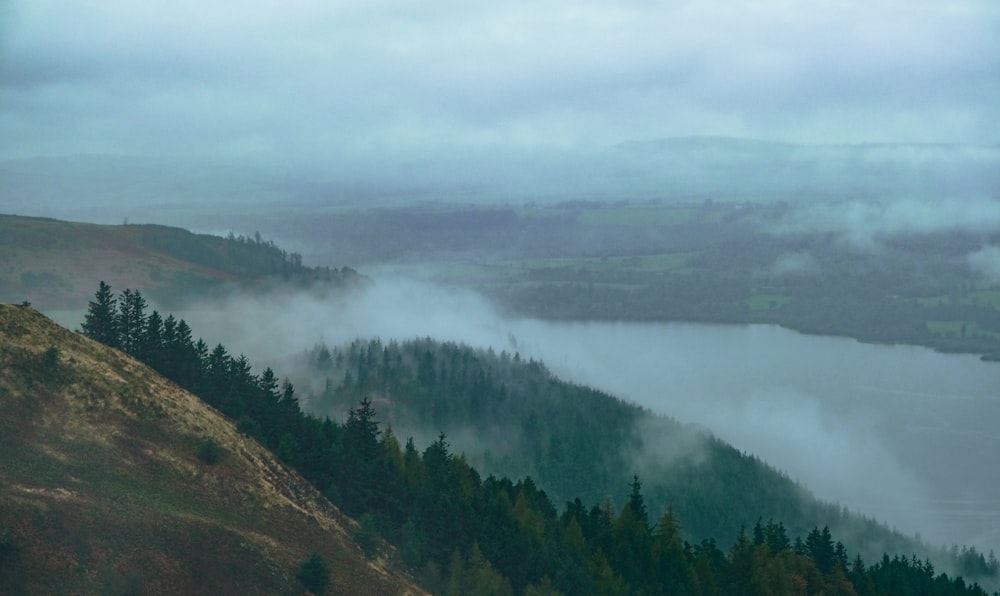 a foggy view of a valley and a lake